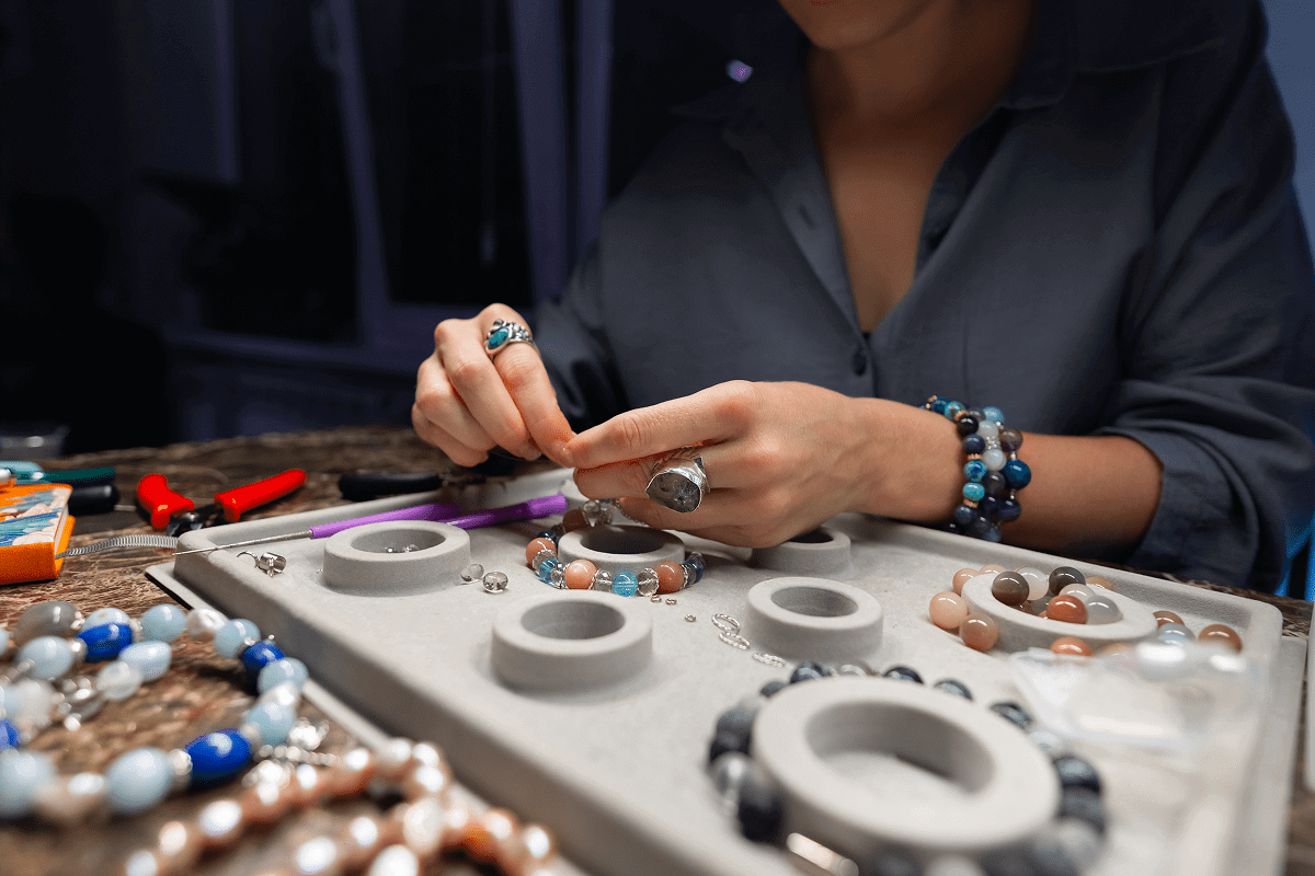 Person making handmade beaded bracelets.