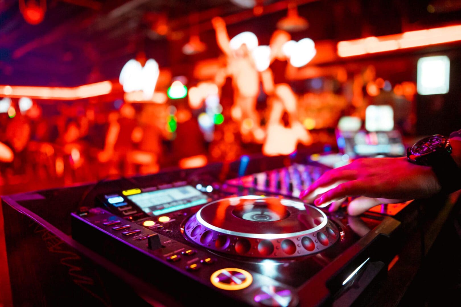 DJ mixing music at a vibrant nightclub.